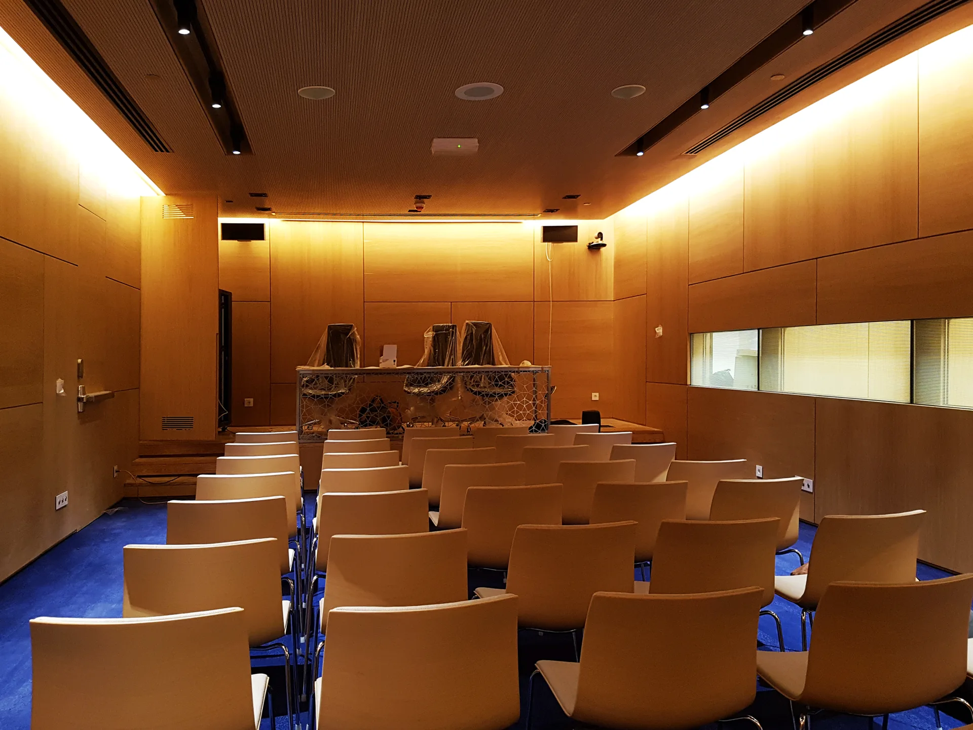 Timber-lined auditorium with tiered seating and a concealed light cove