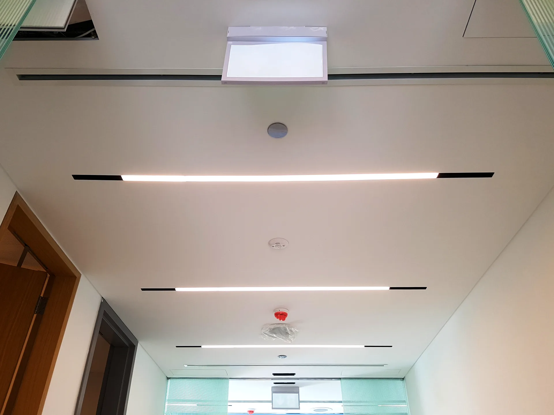 Plasterboard ceiling with recessed linear lighting and integrated services