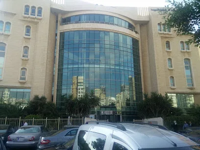 Khatib & Alami offices — curved glazed frontage between stone wings