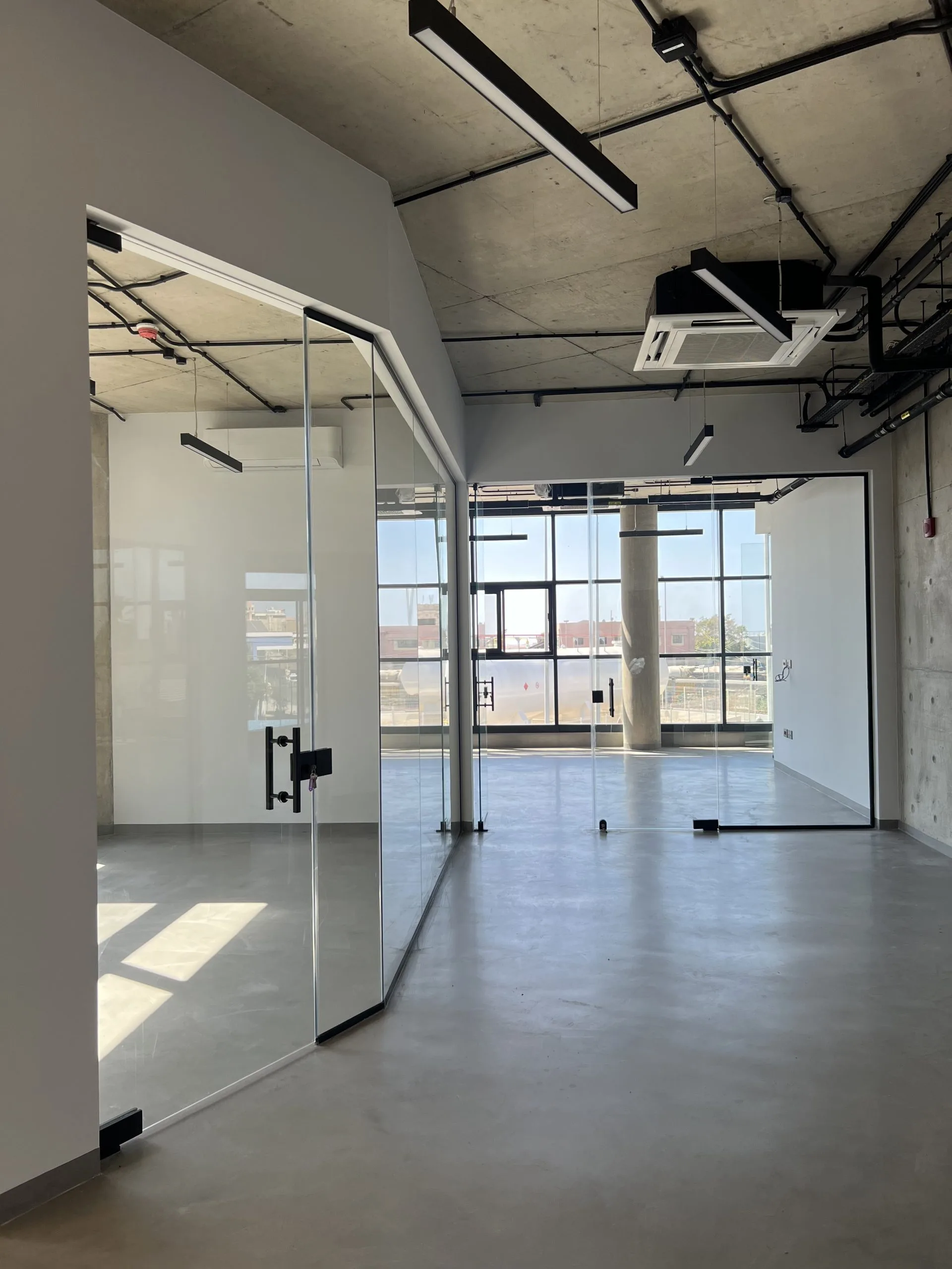 Frameless glass partitions and doors dividing the office floor