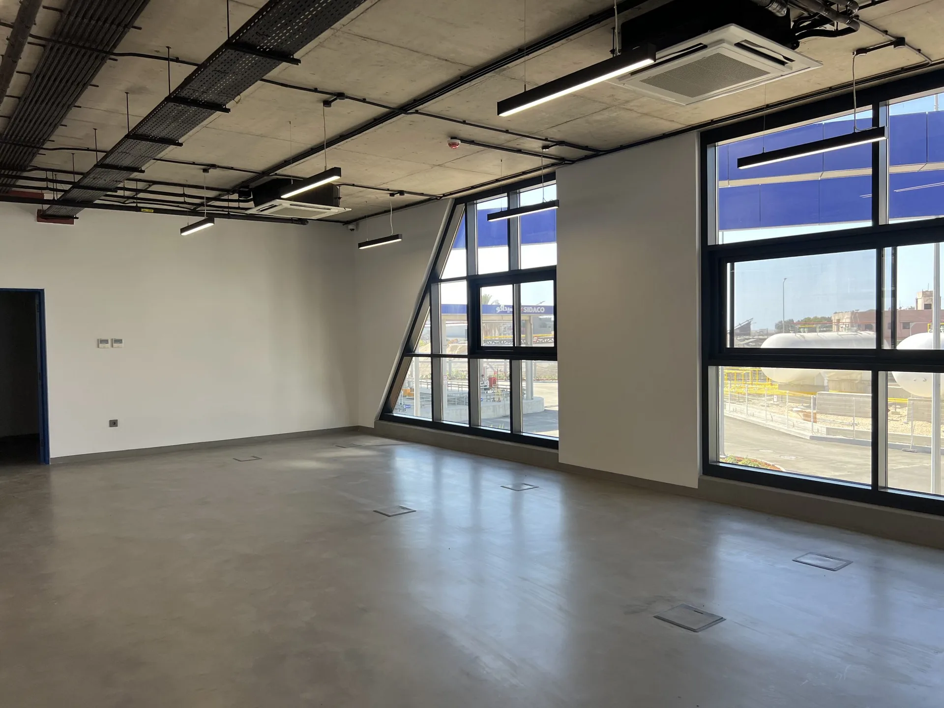 Open-plan office floor — exposed services, raked glazing and floor boxes