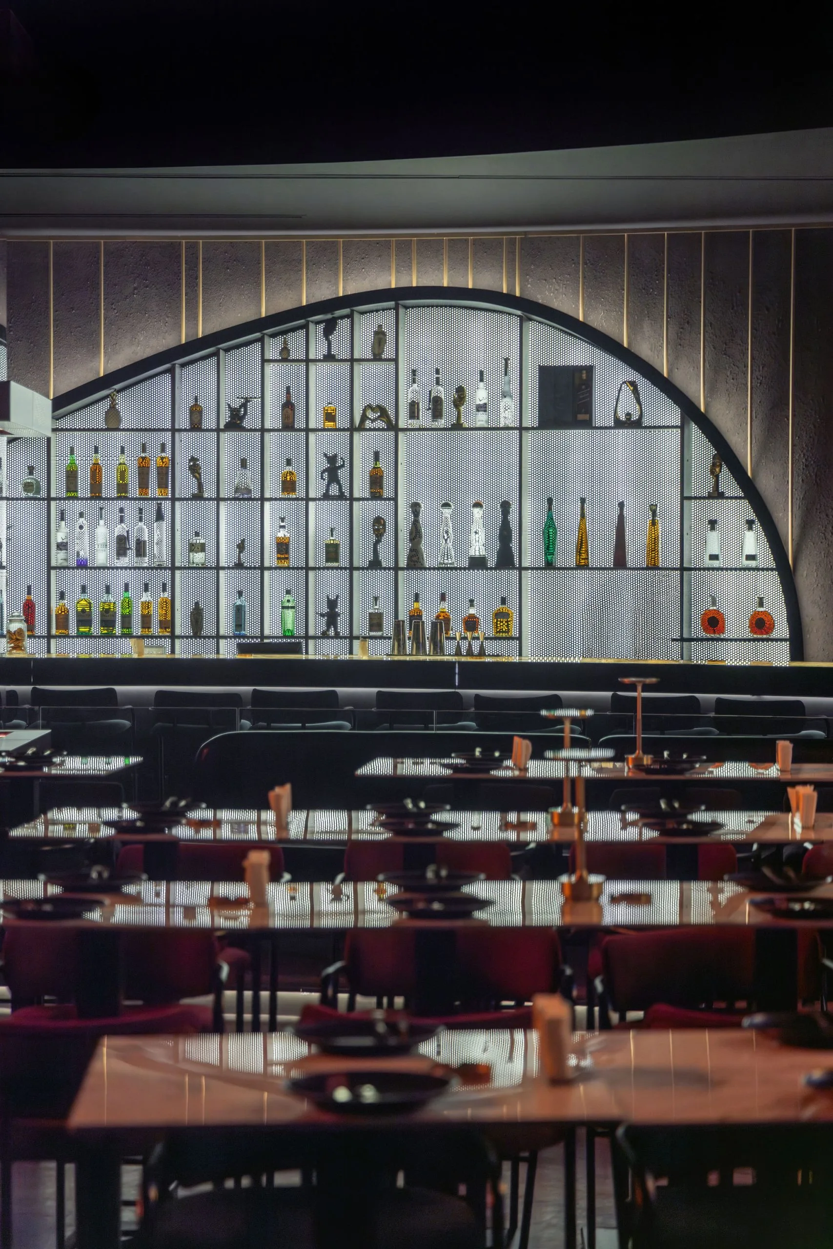 Dining room set for service in front of the arched bottle wall