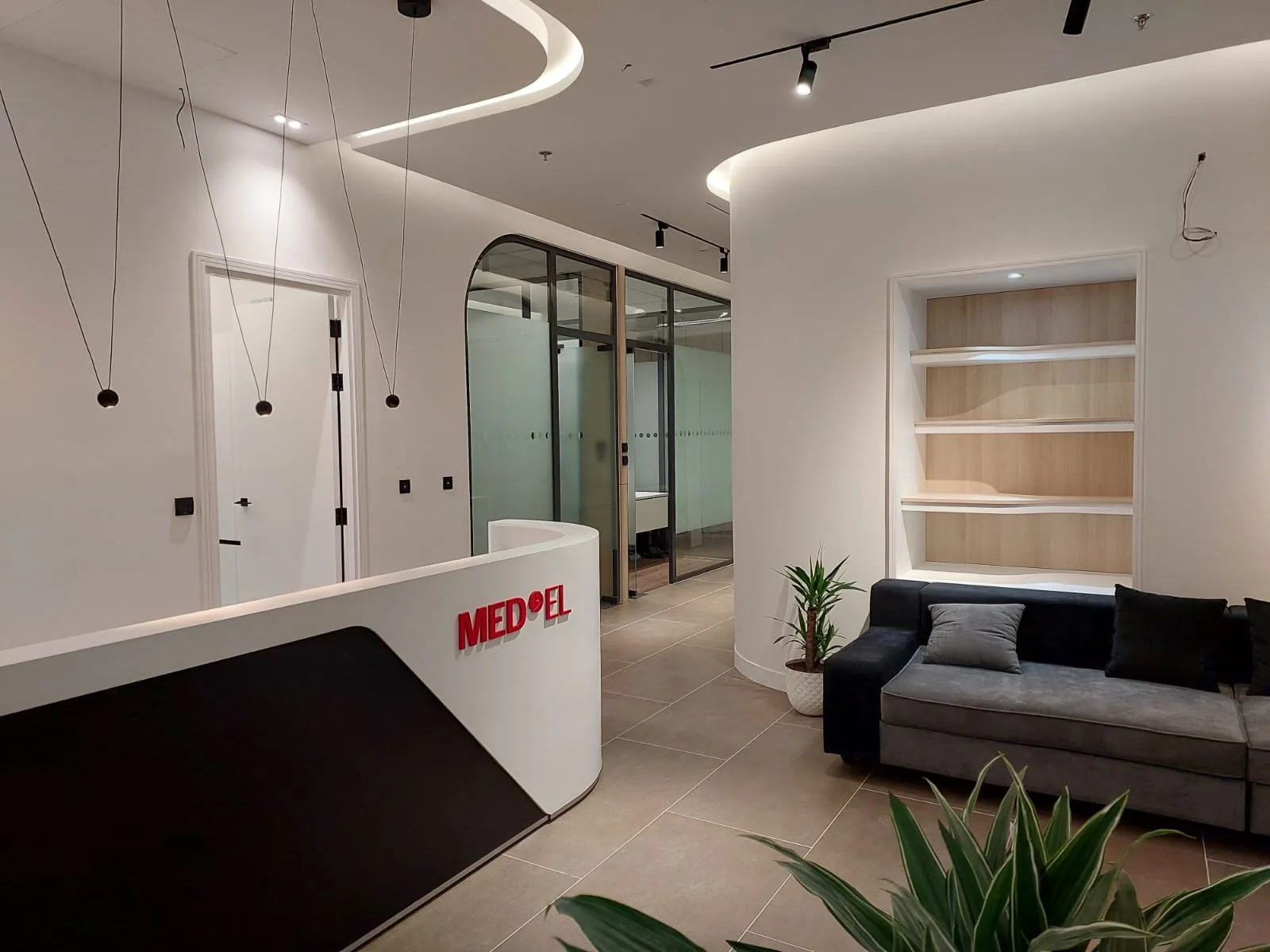 Entrance area — the curved reception counter beside an arched glazed partition and shelving niche