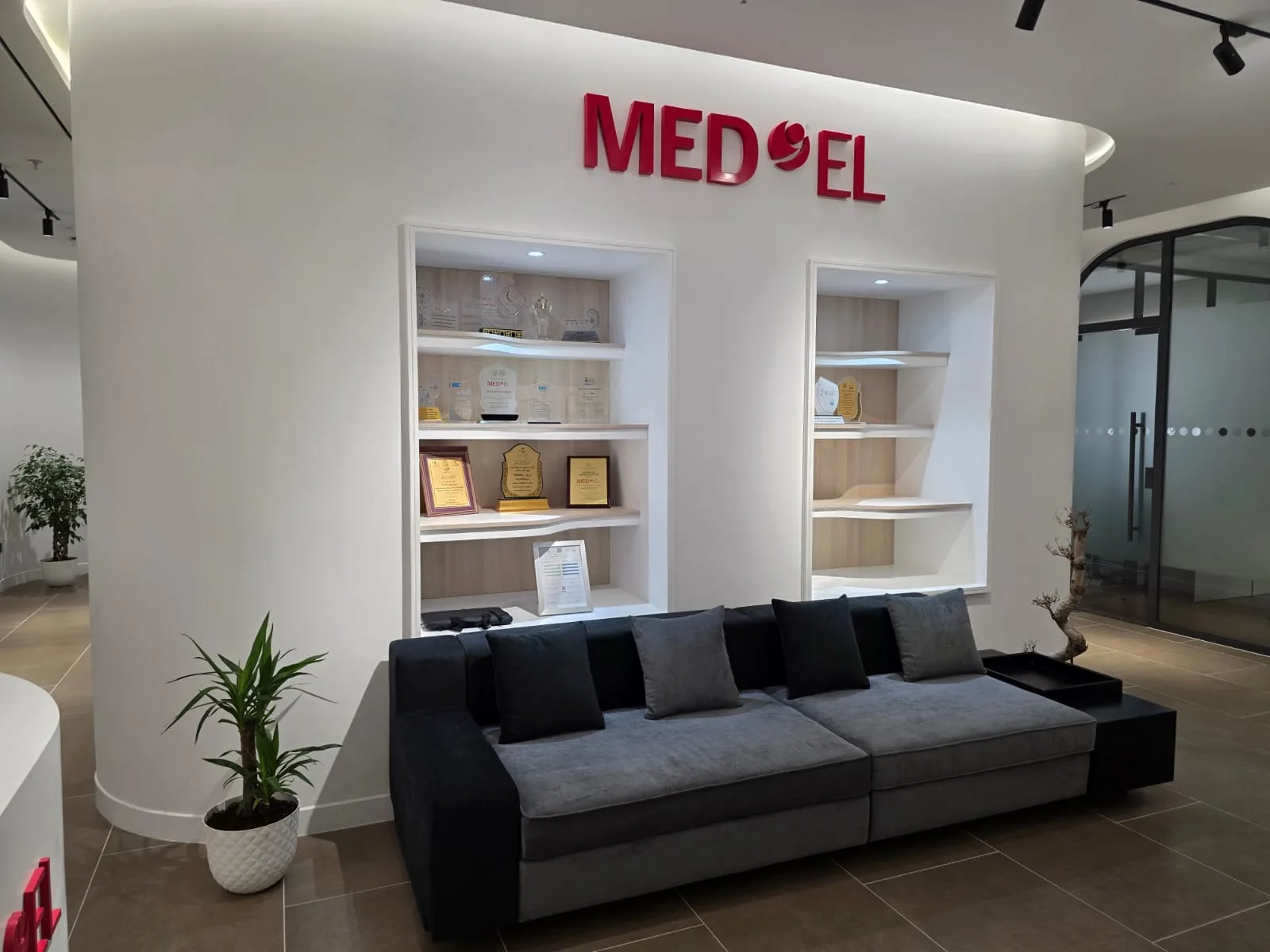 MED-EL KSA headquarters — reception lounge beneath the brand signage and display niches