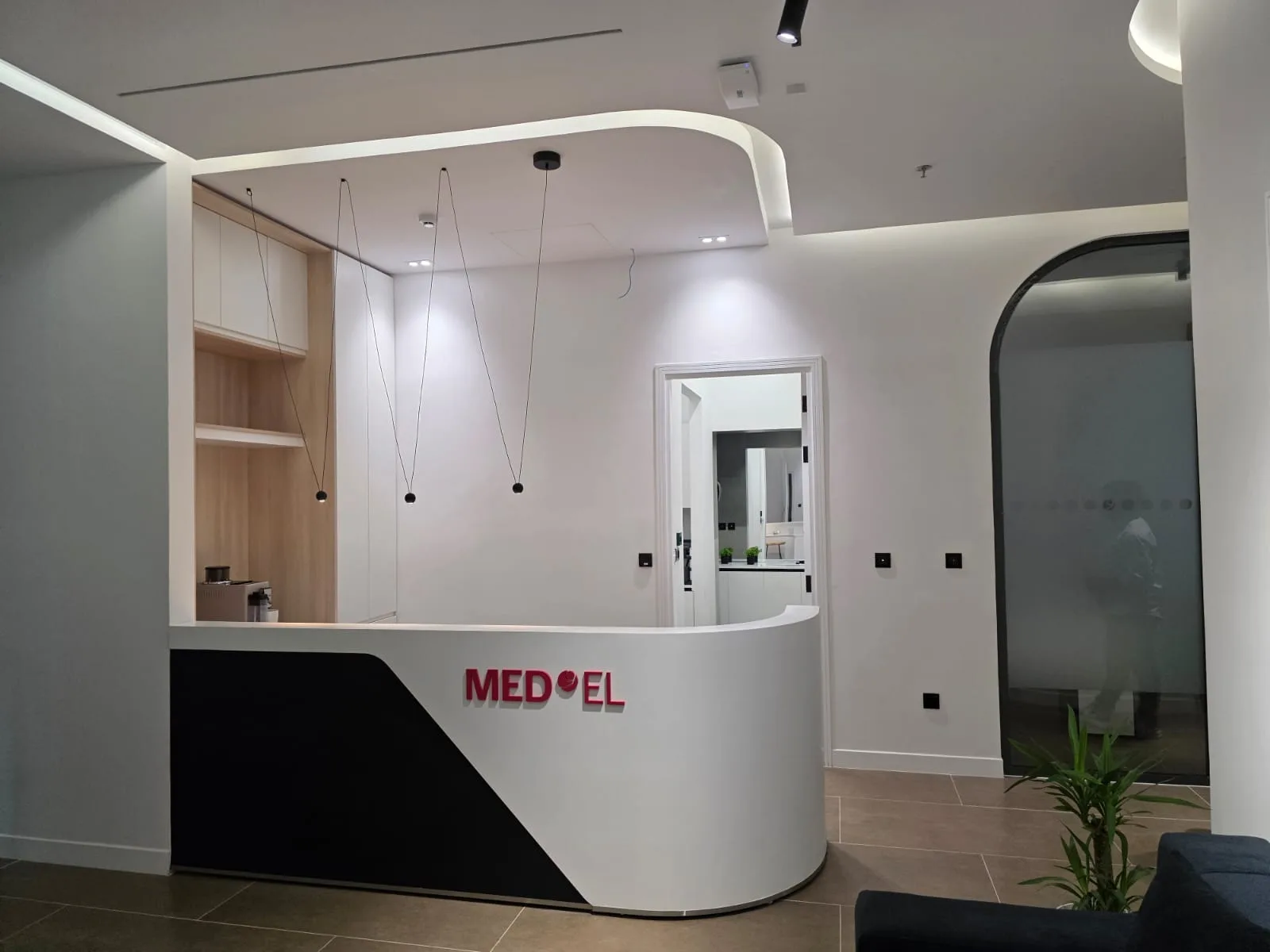 Reception counter with timber joinery, pendant lighting and a curved bulkhead above