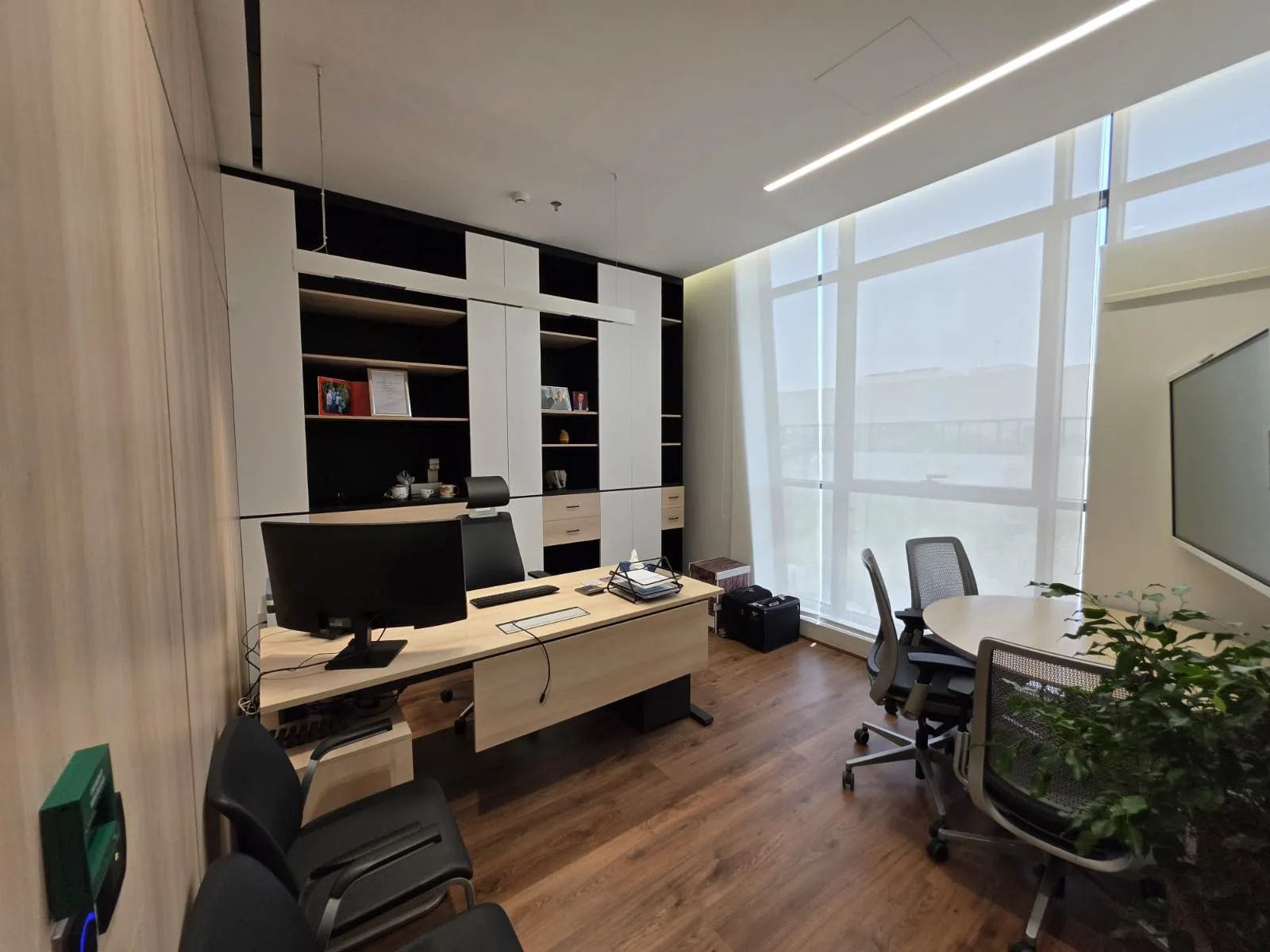 Executive office — fitted joinery wall and desk against full-height glazing